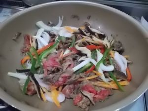 ニラ以外の野菜と牛肉を炒める。